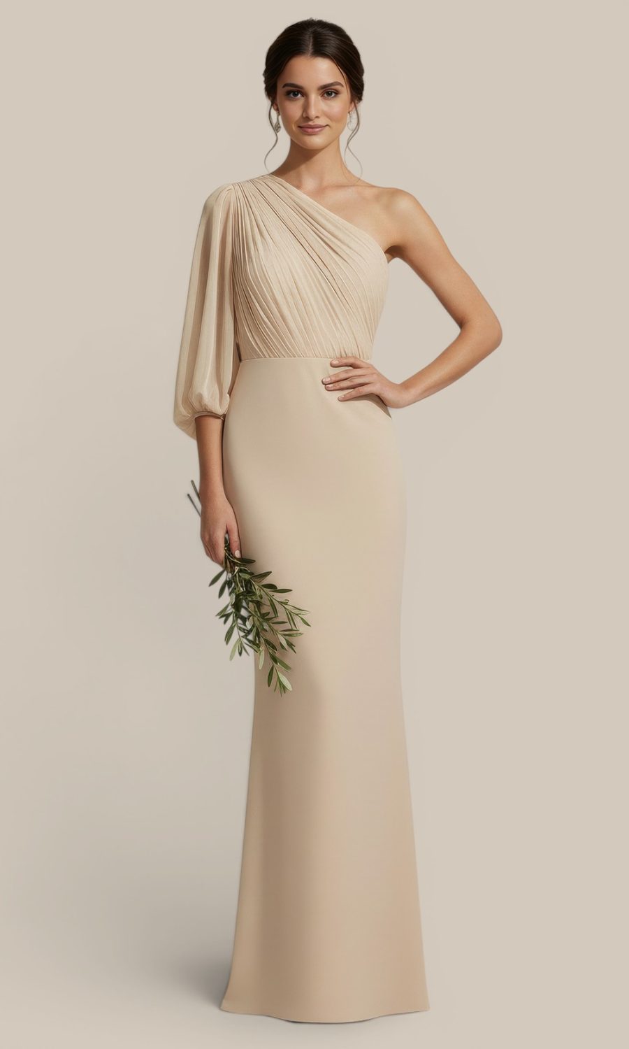 An elegant bridesmaid wearing a premium one shoulder beige dress, holding delicate olive foliage for a cohesive, earthy wedding aesthetic. Statement features are one sleeve detail and lightweight chiffon.