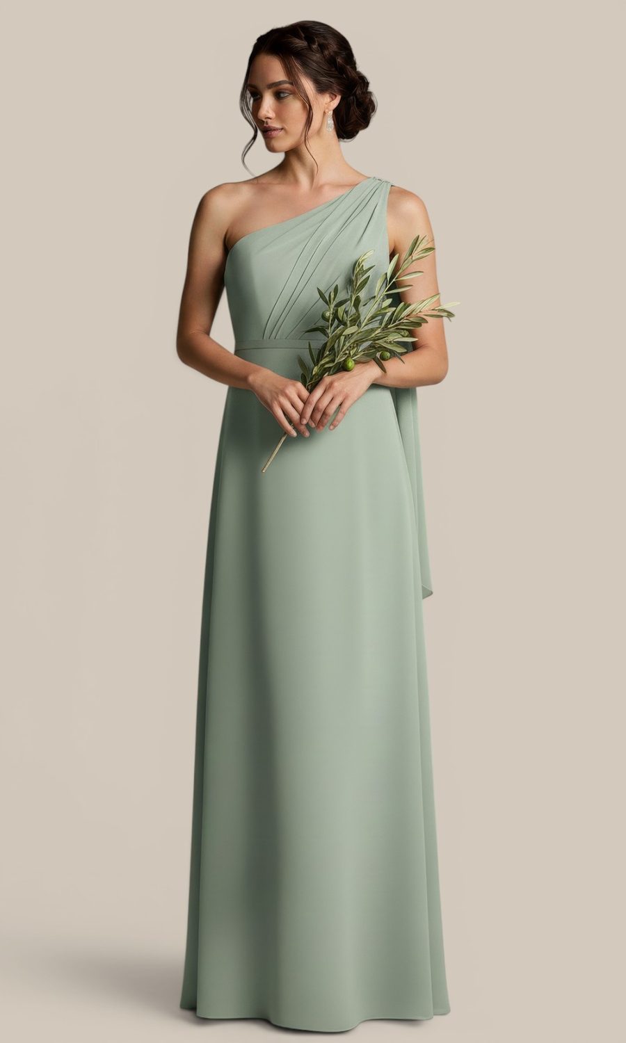 A bridesmaid wearing a stunning sage green boutique bridesmaid dress, holding delicate olive branches for a cohesive earthy wedding aesthetic.