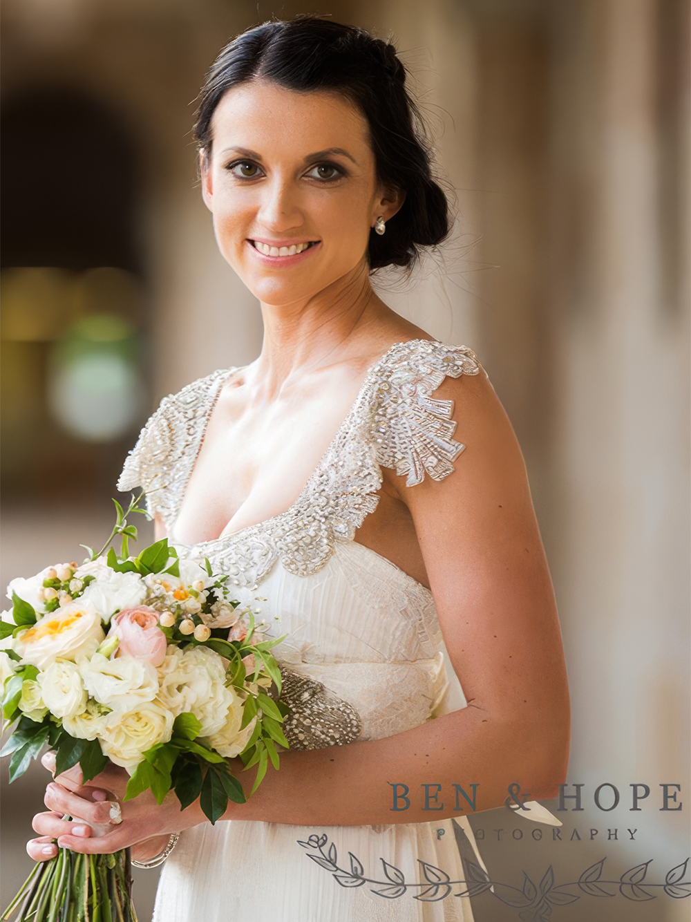 Elegant portrait of the bride holding her floral bouquet.
