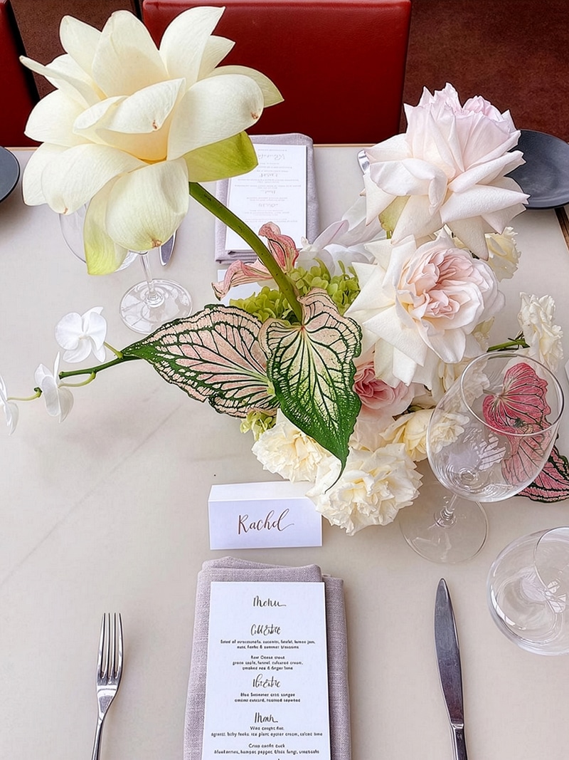 wedding-tables-flowers A stunning wedding reception floral arrangement featuring soft blush and pastel blooms, perfectly curated to coordinate with our boutique mix and match bridesmaid dresses.